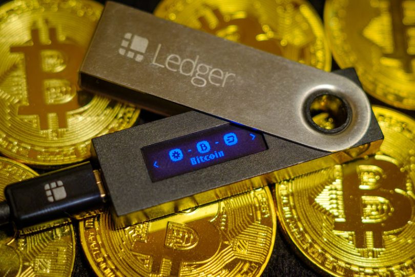 crypto wallet ledger nano s lying on golden bitcoin coins